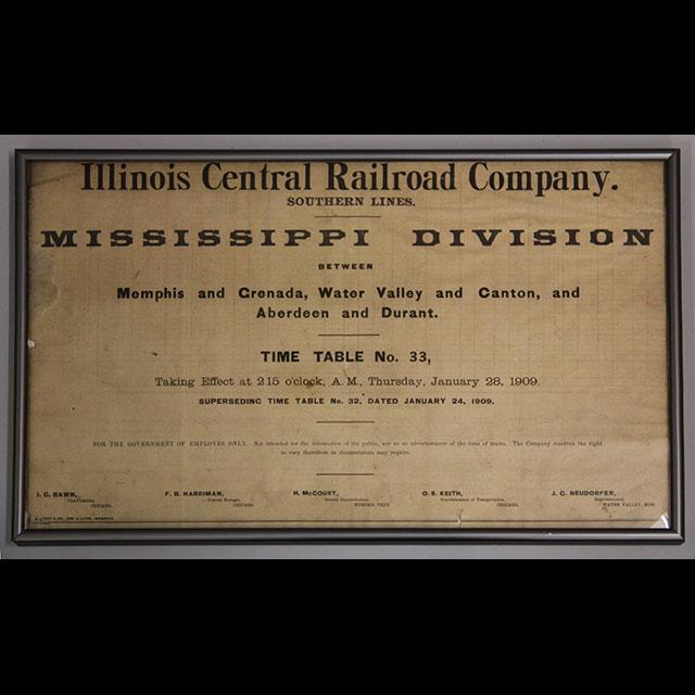 A color photograph of a timetable from the Illinois Central Railroad Company. The time table has black text printed on paper that has yellowed with age. This timetable was used in 1909, and gives information for time, location, and railroad superintendents. 